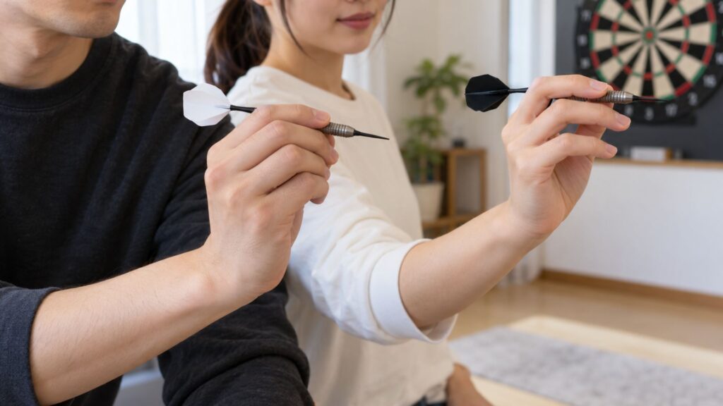 2人の男女が異なる指の位置でダーツを持ち、グリップの違いを確認している様子